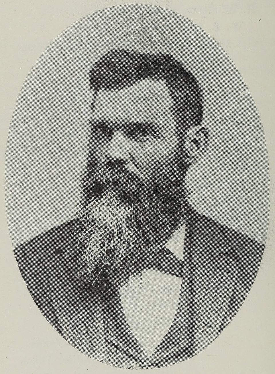 Retrato de Julien Reverchon, un hombre barbudo con traje, en un marco ovalado.